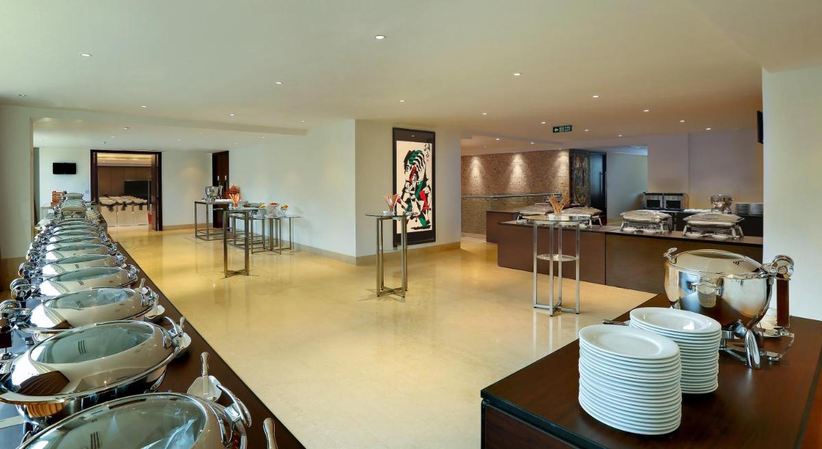 a bathroom with a row of sinks and toilets at Mercure Hyderabad KCP Banjara Hills, An Accor Hotel in Hyderabad
