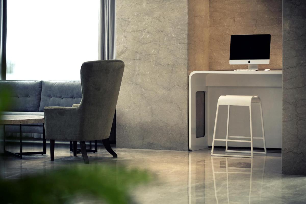 a living room with a chair and a computer on a desk at Mercure Hyderabad KCP Banjara Hills, An Accor Hotel in Hyderabad