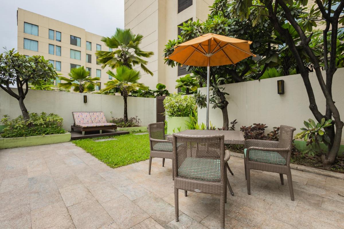 a patio with a table and chairs and an umbrella at Hyatt Pune in Pune
