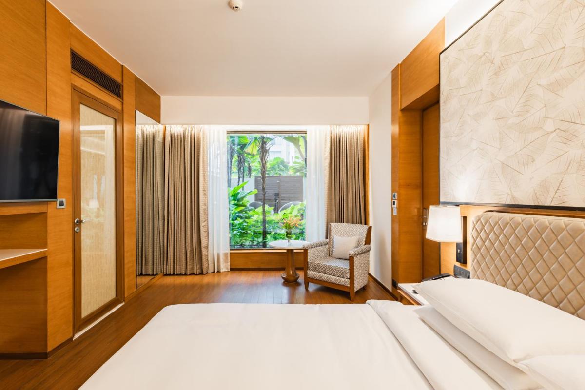 a hotel room with a bed and a television at Hyatt Pune in Pune
