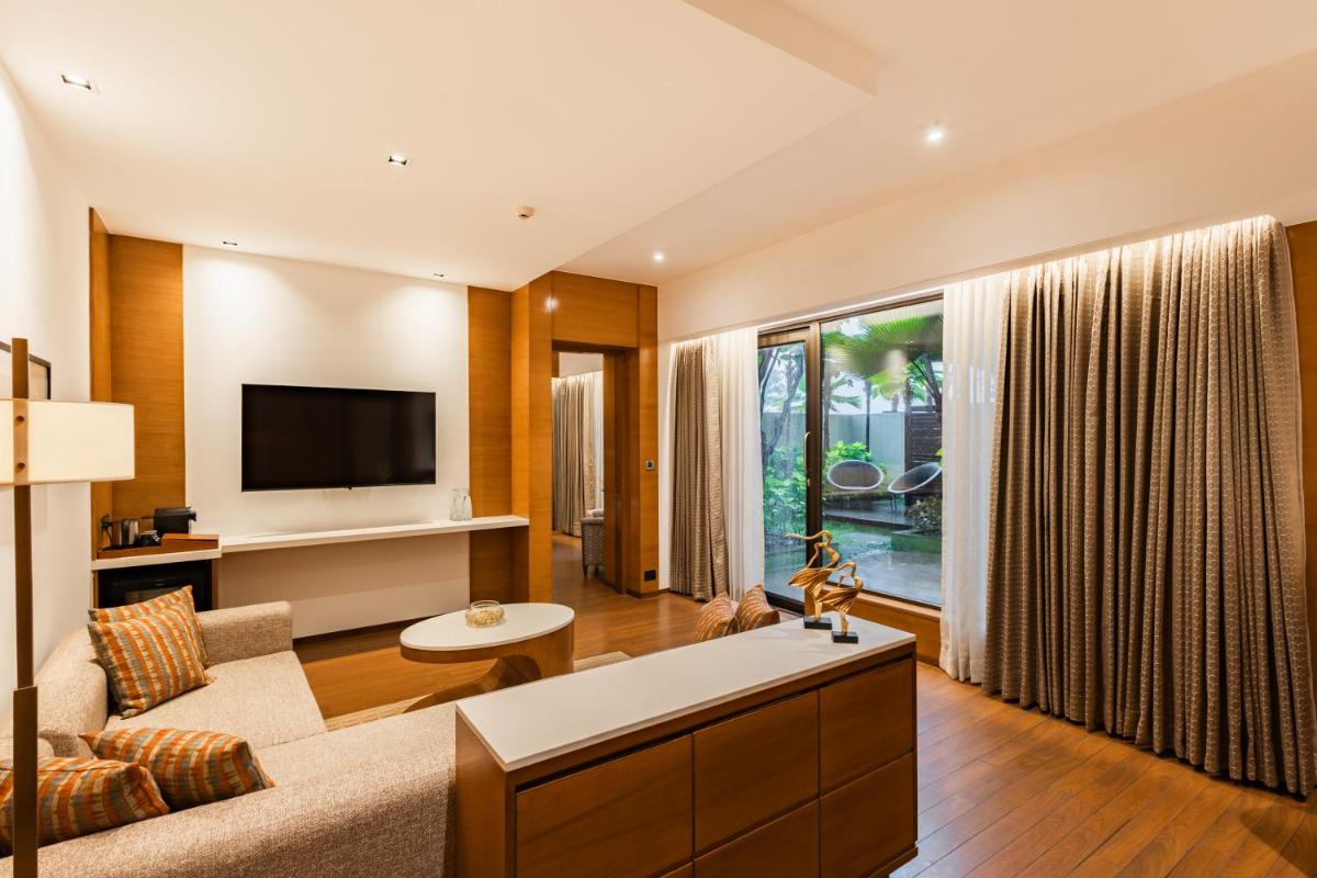 a living room with a couch and a tv at Hyatt Pune in Pune