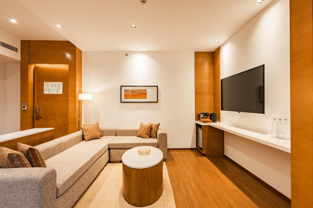a living room with a couch and a tv at Hyatt Pune in Pune
