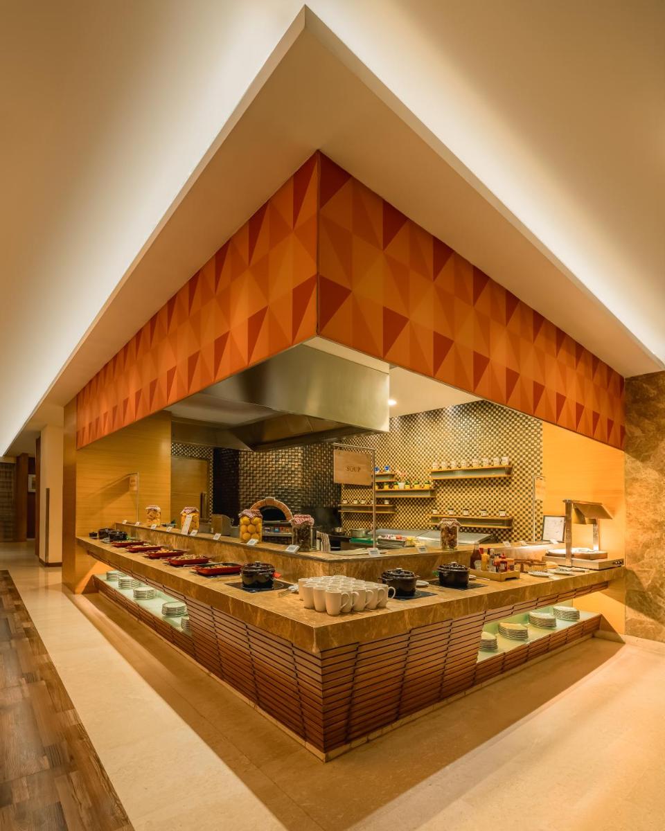a large kitchen with orange and brown tiles at Hyatt Pune in Pune