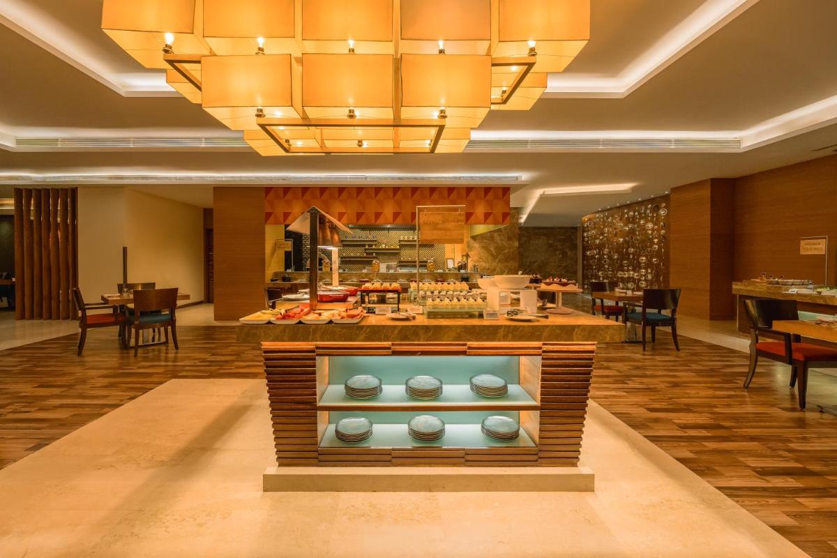 a restaurant with a buffet in the middle of a room at Hyatt Pune in Pune