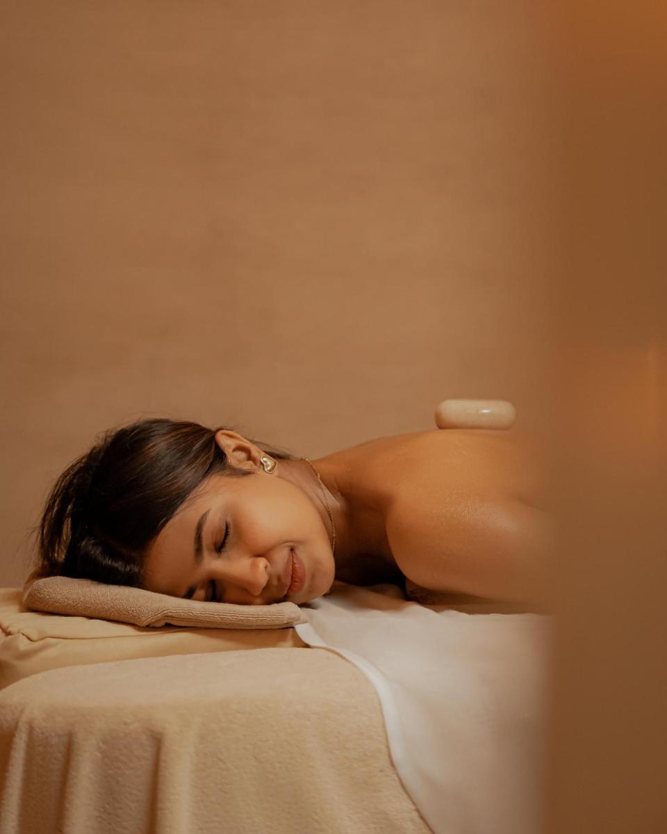 a woman laying on top of a bed at Hyatt Pune in Pune