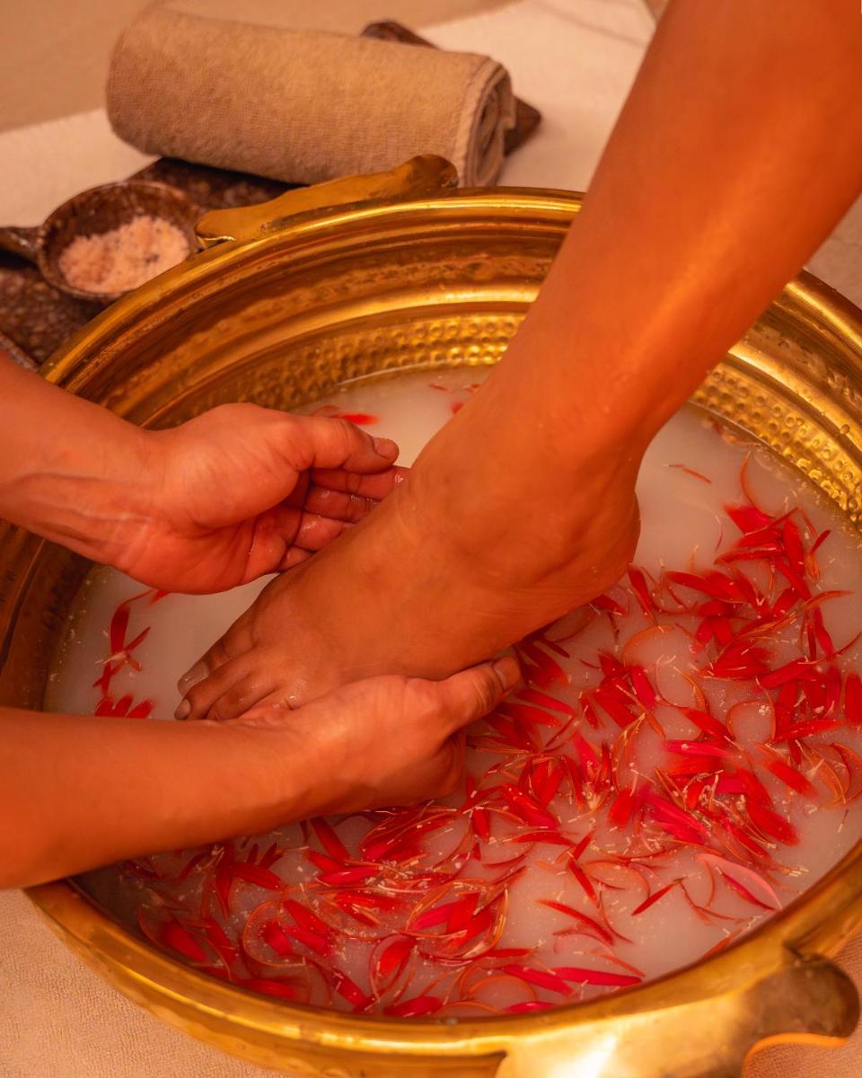 two people dipping their feet in a bowl of red substance at Hyatt Pune in Pune