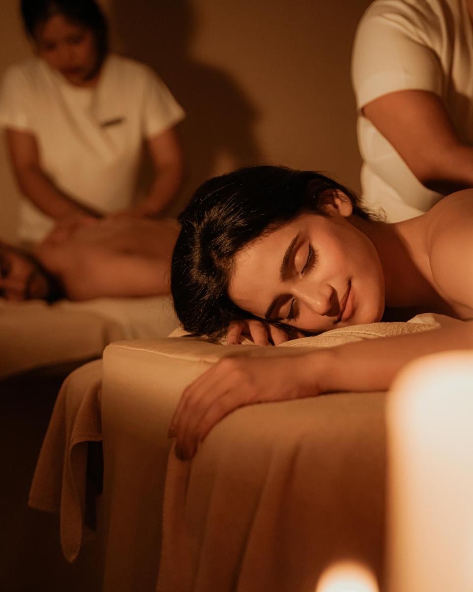 a woman is laying on a bed with her head on a table at Hyatt Pune in Pune
