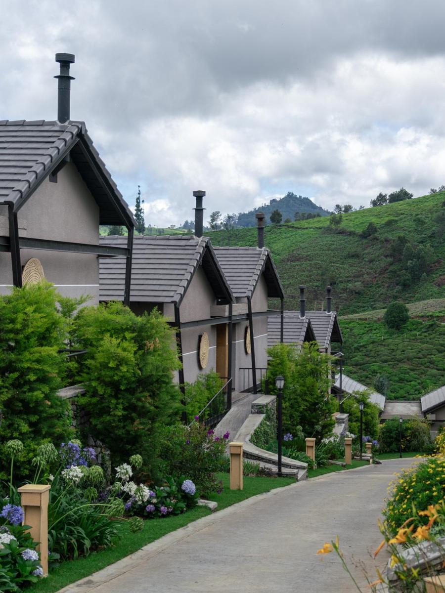 a row of houses on a hill next to a road at WelcomHeritage Ayatana Ooty in Ooty