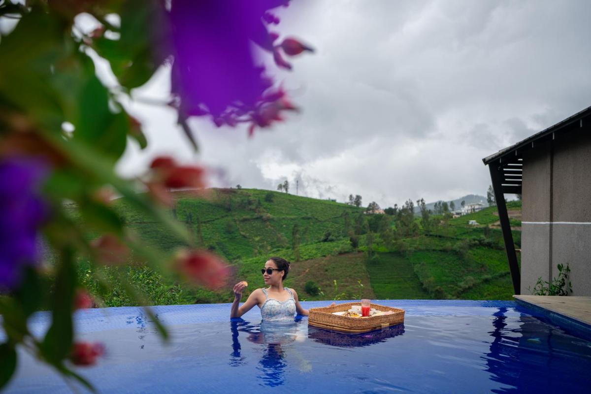 a woman in a pool of water with a table at WelcomHeritage Ayatana Ooty in Ooty