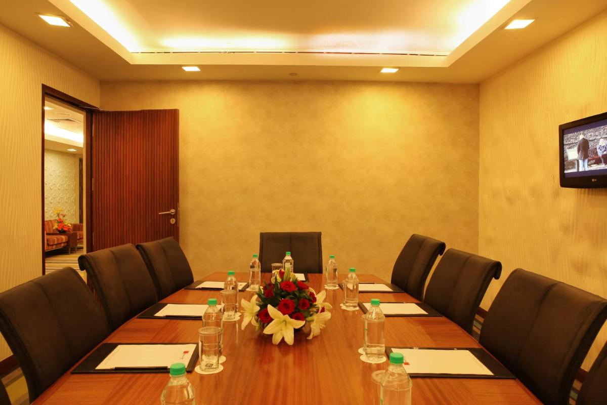 a conference room with a long table with a flower on it at The Metropolitan Hotel & Spa New Delhi in New Delhi