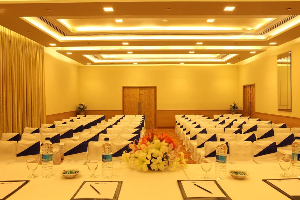 a large room with a long table with glasses and flowers at The Metropolitan Hotel & Spa New Delhi in New Delhi
