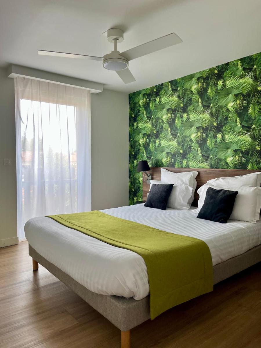 une chambre avec un grand lit avec un mur végétal dans l'établissement ATHOME RESIDENCE ET SPA, à La Rochelle