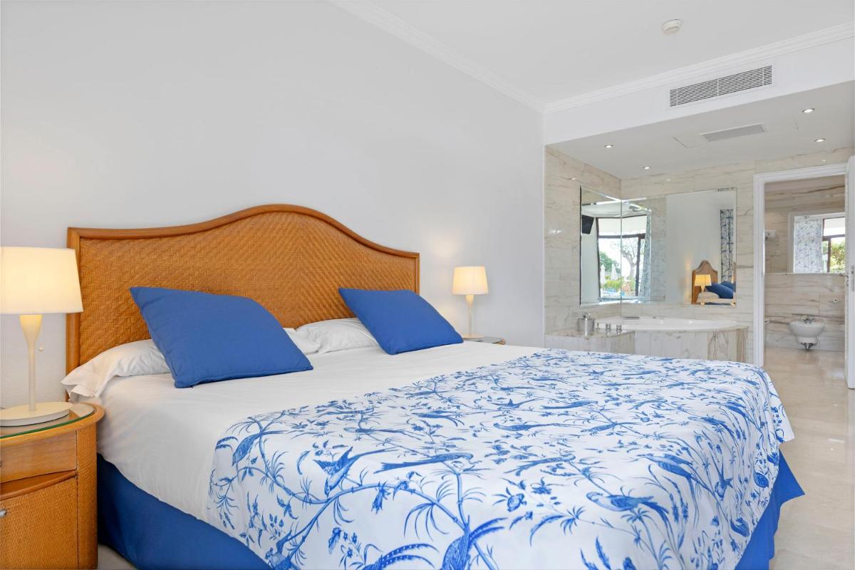 Un dormitorio con una cama con sábanas azules y blancas. en Anfi del Mar 2, en La Playa de Arguineguín