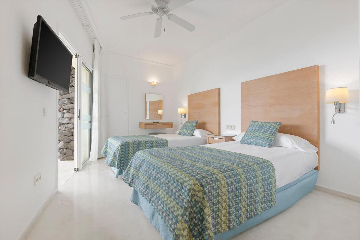 Una habitación de hotel con dos camas y un televisor de pantalla plana. en Anfi del Mar 2, en La Playa de Arguineguín