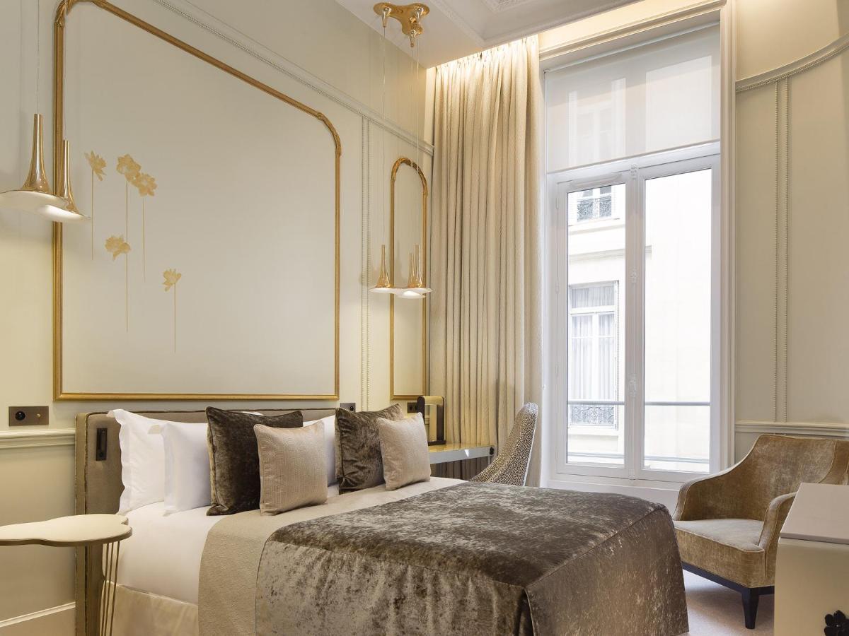 une chambre avec un lit et une grande fenêtre dans l'établissement Le Narcisse Blanc, à Paris