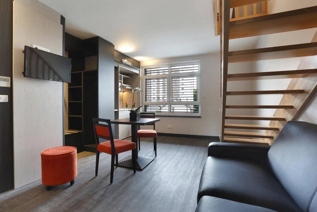 un petit salon avec une table et un canapé dans l'établissement The Originals Boutique, Hôtel d'Alsace, Strasbourg Sud, à Illkirch-Graffenstaden