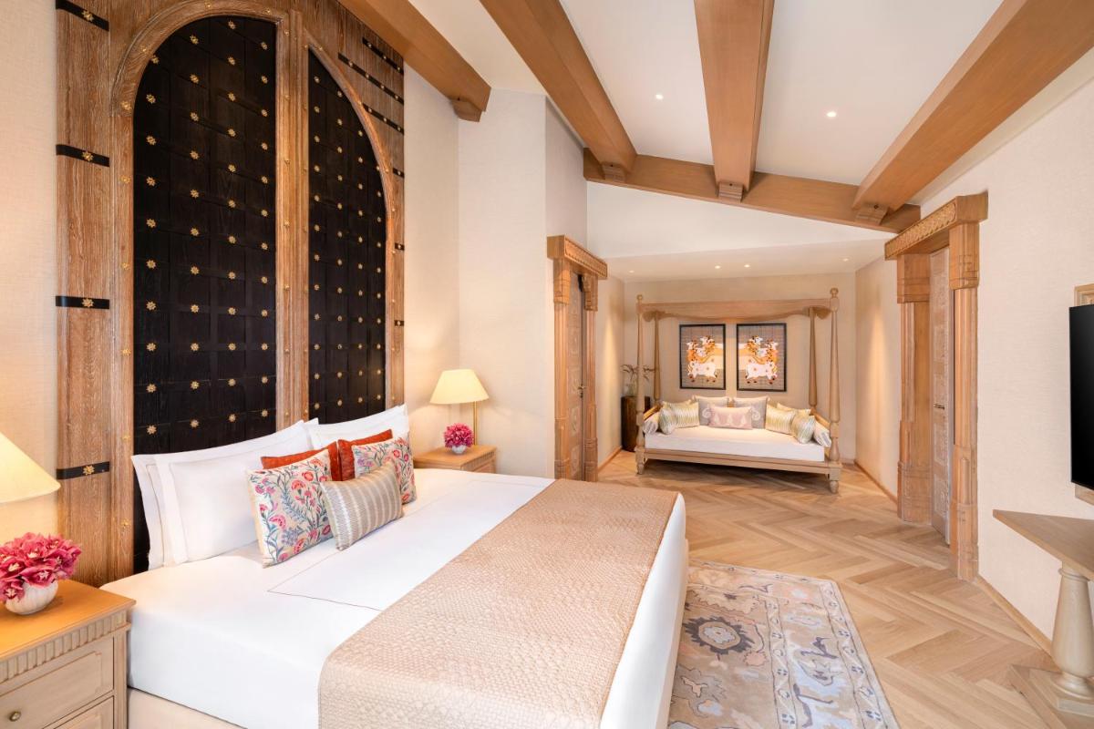 a bedroom with a large white bed and a tv at Taj Aravali Resort & Spa Udaipur in Udaipur