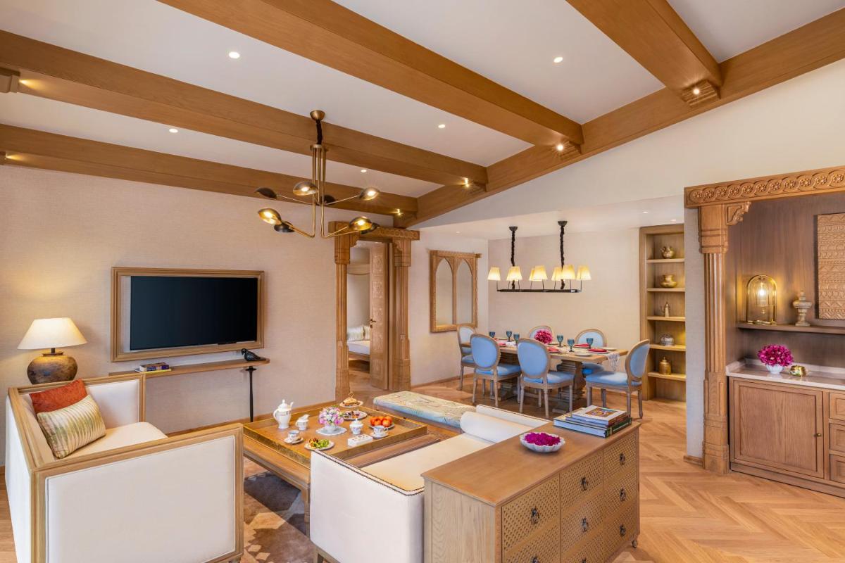 a living room with a table and a dining room at Taj Aravali Resort & Spa Udaipur in Udaipur