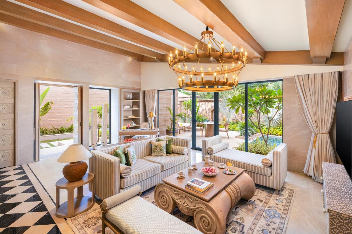 a living room with couches and a chandelier at Taj Aravali Resort & Spa Udaipur in Udaipur