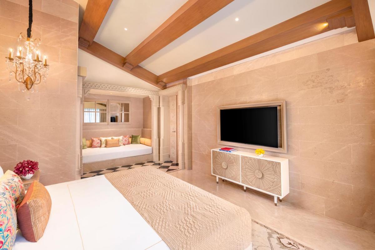 a bedroom with a large bed and a tv at Taj Aravali Resort & Spa Udaipur in Udaipur