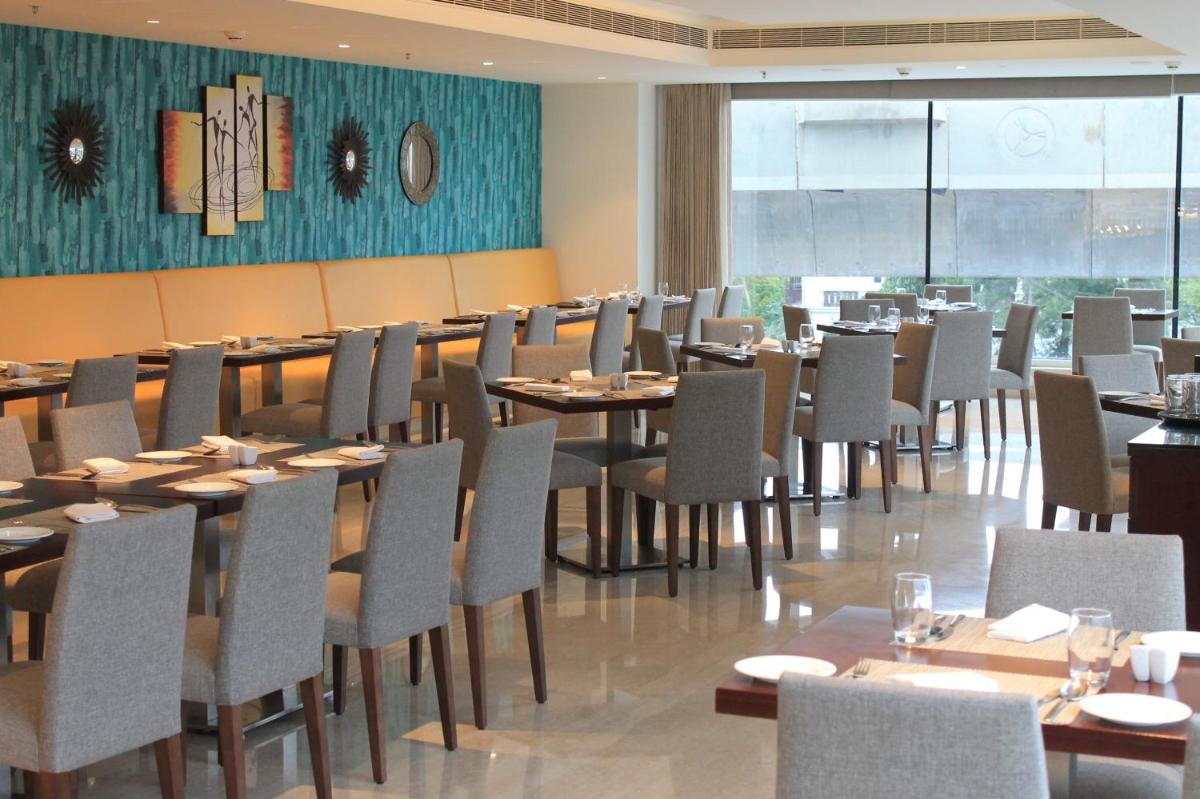 a dining room filled with tables and chairs at Mercure Hyderabad KCP Banjara Hills, An Accor Hotel in Hyderabad