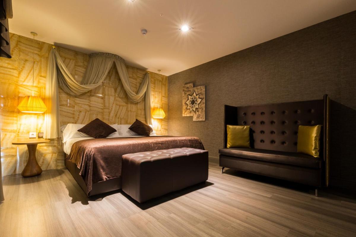 1 dormitorio con cama y banco. en Sant Jordi Boutique Hotel, en Calella 47 fotos más