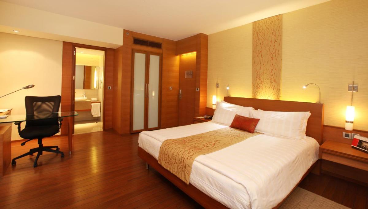 a hotel room with a bed and a desk and a bedroom at Hyatt Pune in Pune