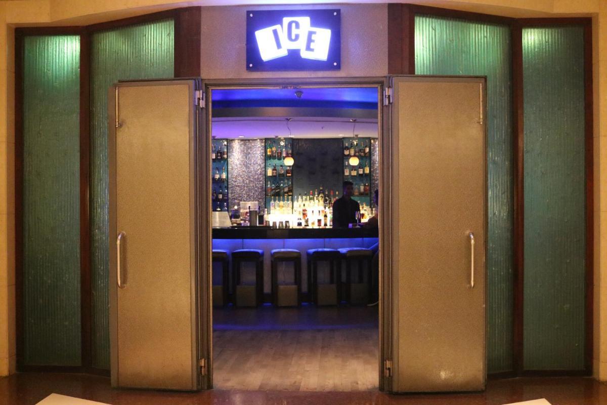 an open door to a bar with a man in the background at Taj MG Road Bengaluru in Bengaluru an open door to a bar with a man in the background at Taj MG Road Bengaluru in Bengaluru