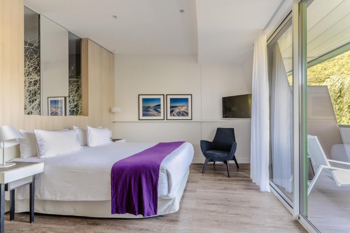 une chambre avec un lit, un bureau et une chaise dans l'établissement Eau Thermale Avène l'hôtel, à Avène