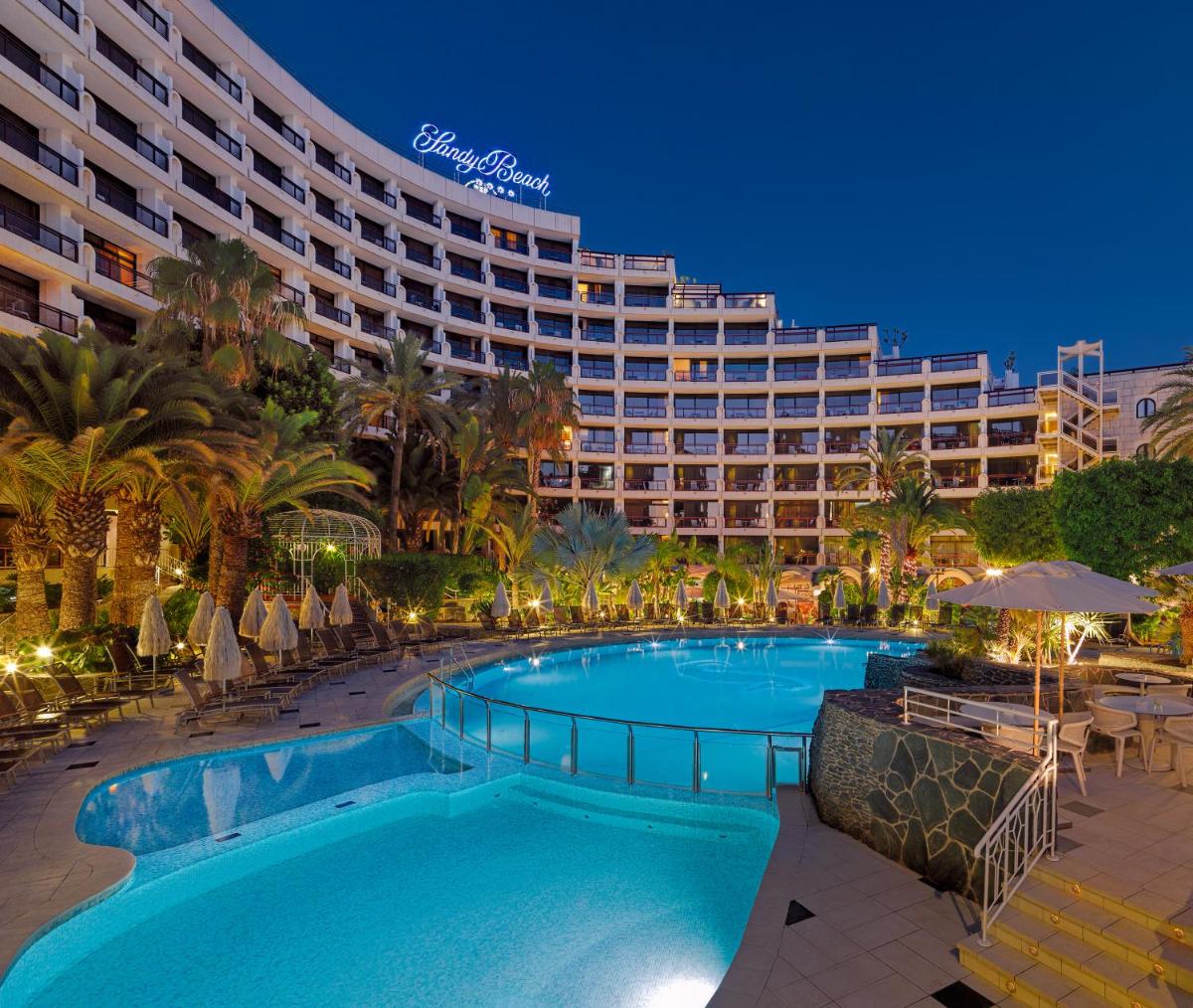 una piscina resort con un hotel en el fondo en Seaside Sandy Beach, en Playa del Inglés