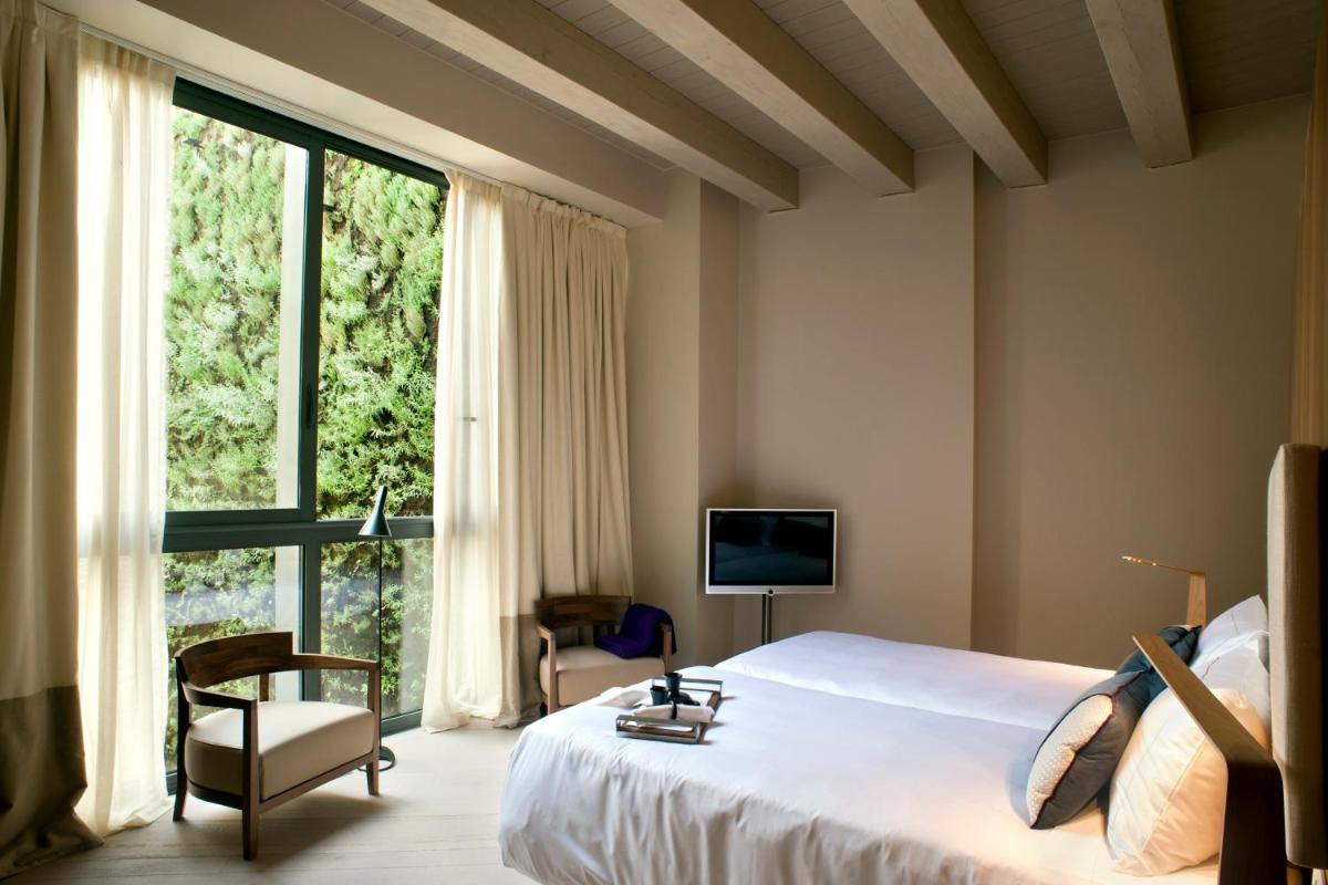 Un dormitorio con una cama grande y una ventana grande. en Mercer Hotel Barcelona, en Barcelona