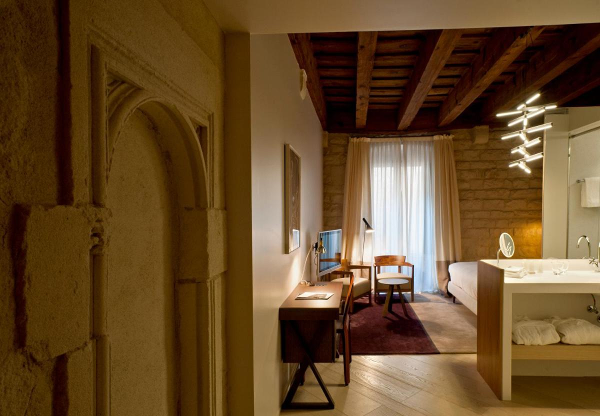 Un dormitorio con una cama y un escritorio en una habitación. en Mercer Hotel Barcelona, en Barcelona