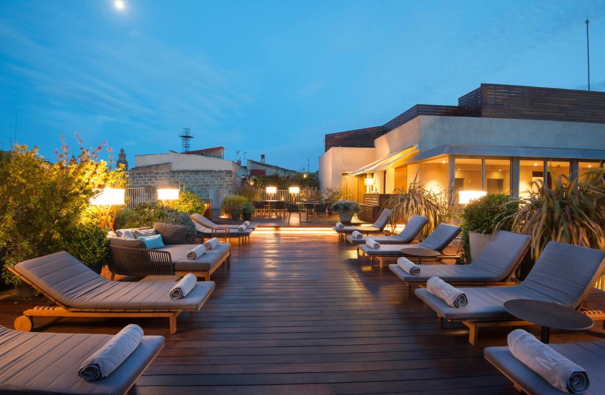 una fila de tumbonas en una terraza por la noche en Mercer Hotel Barcelona, en Barcelona