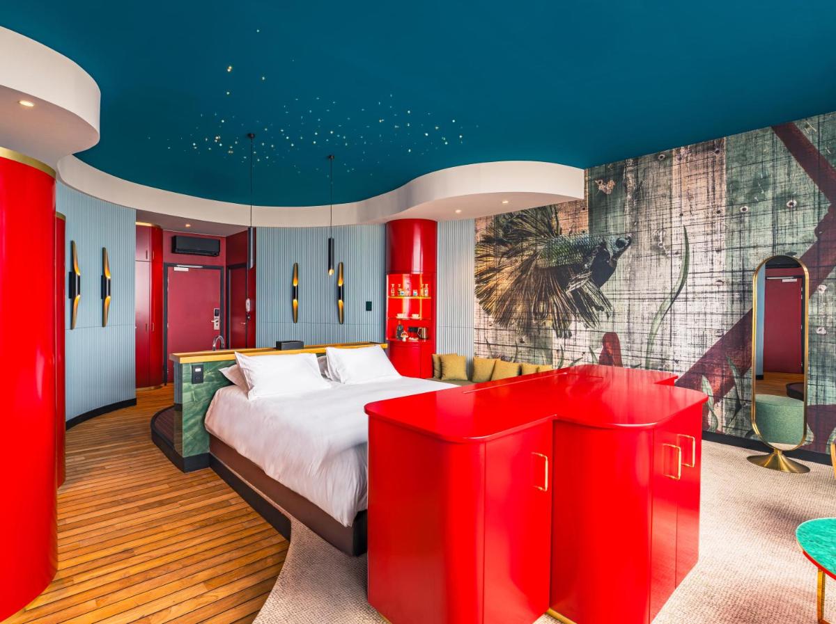 une chambre avec un grand lit aux murs rouges dans l'établissement Hotel Atlantic, à Wimereux