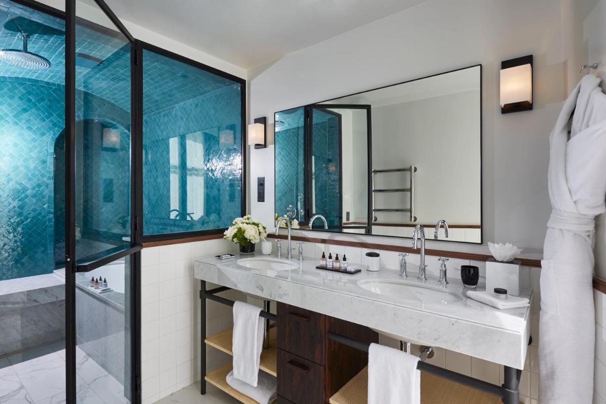 une salle de bain avec deux lavabos et un grand miroir dans l'établissement Le Roch Hotel & Spa, à Paris