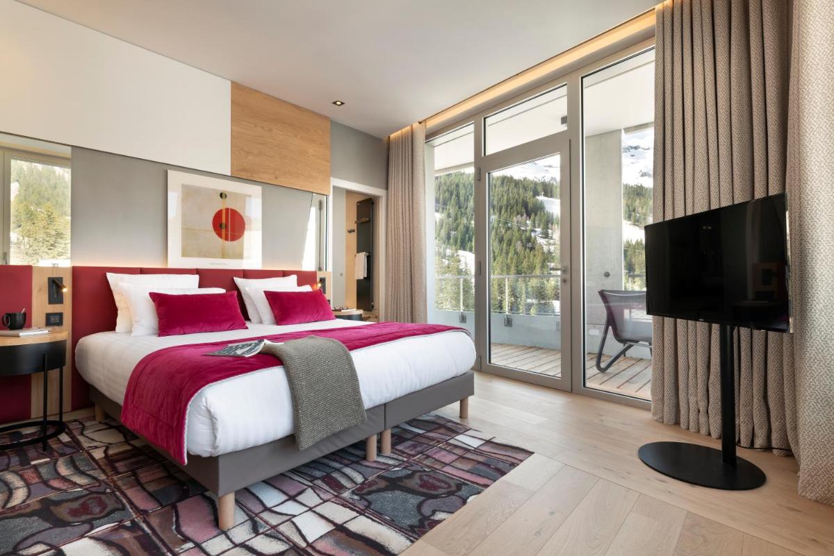 une chambre avec un lit et une télévision à écran plat dans l'établissement MGM Hôtels & Résidences - Hôtel Alhéna, à Flaine 21 autres photos