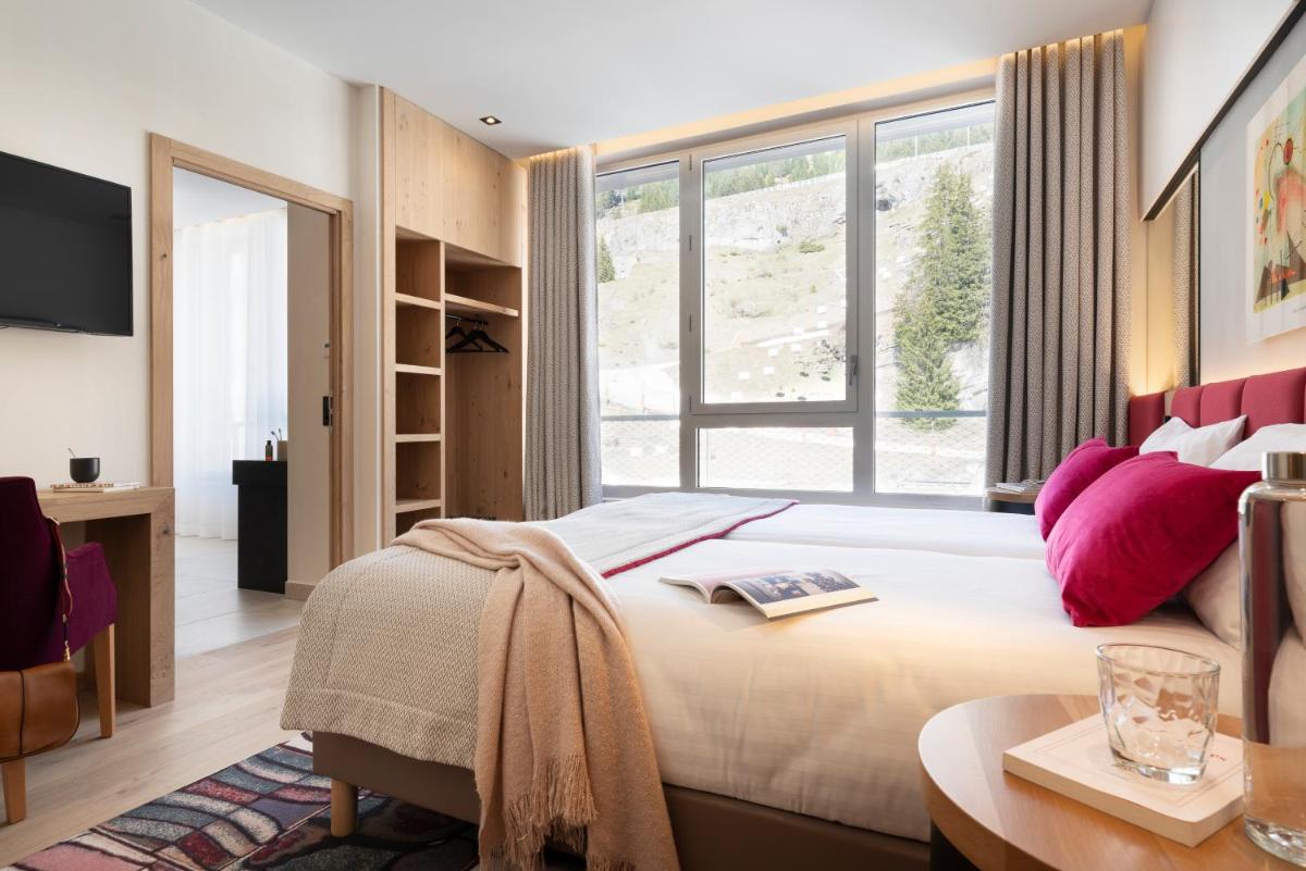 une chambre avec un grand lit et une grande fenêtre dans l'établissement MGM Hôtels & Résidences - Hôtel Alhéna, à Flaine