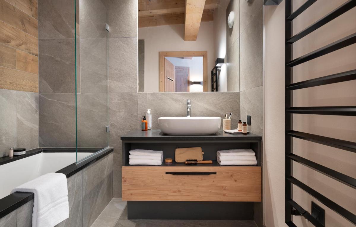une salle de bain avec un lavabo et une baignoire dans l'établissement MGM Hôtels & Résidences - Résidence Le Hameau de l'Ours, à Manigod