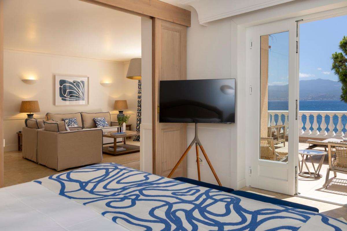 Cet appartement comprend une chambre avec un lit, une télévision et un salon. dans l'établissement Hôtel Les Mouettes - Teritoria, à Ajaccio