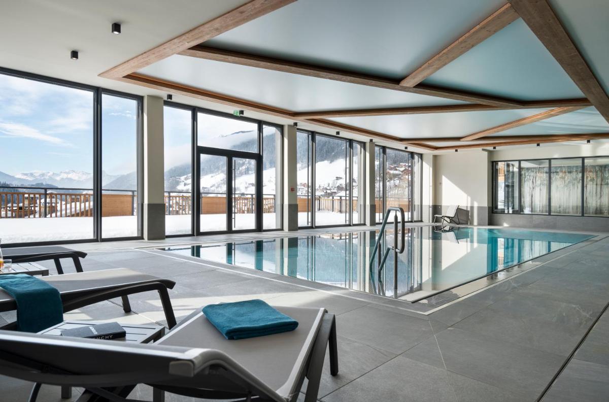 une maison avec une piscine et des fenêtres dans l'établissement MGM Hôtels & Résidences - Résidence Chalets de Joy, au Grand-Bornand