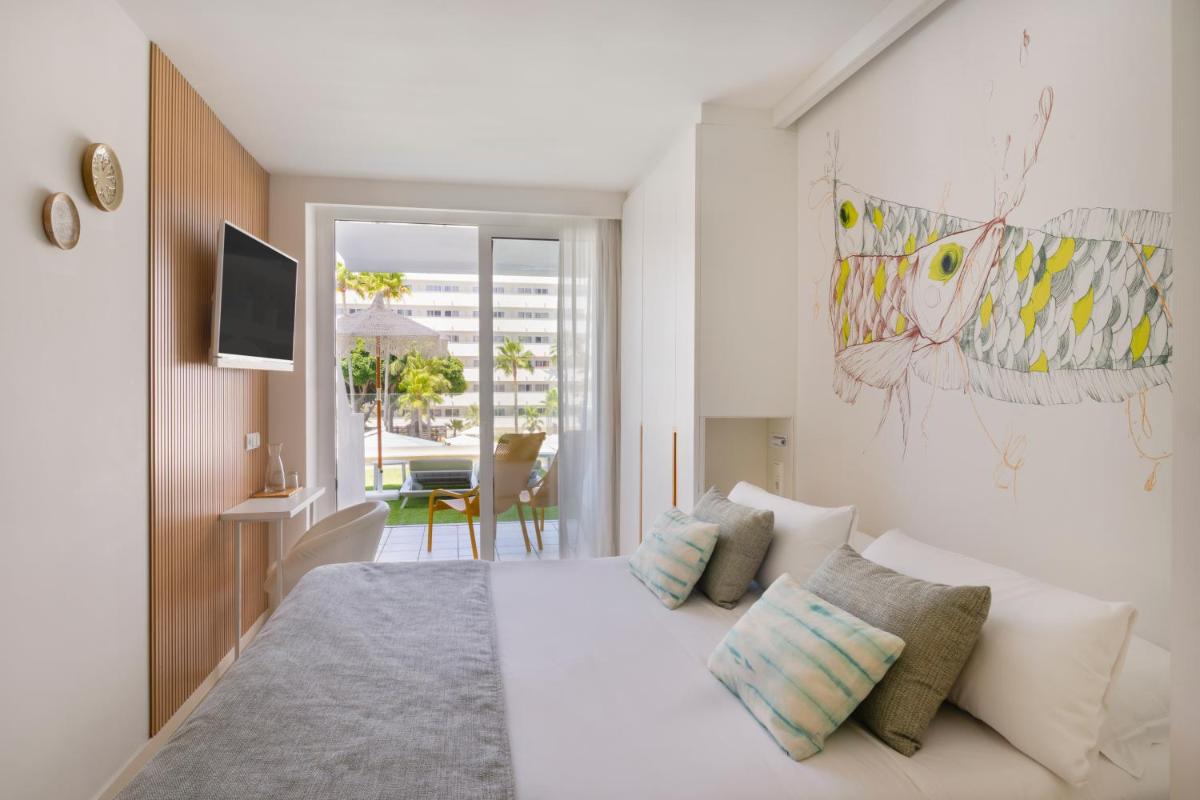 Un dormitorio con una gran cama blanca con almohadas. en Iberostar Waves Bahía de Palma - Adults Only, en Playa de Palma