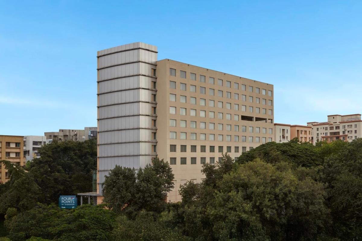 a tall white building in the middle of a city at Four Points by Sheraton Hotel and Serviced Apartments Pune in Pune