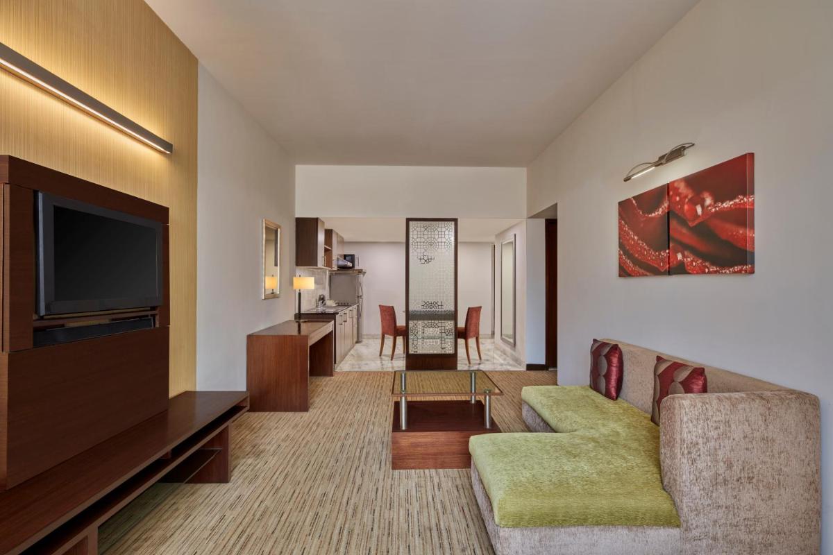 a living room with a couch and a television at Four Points by Sheraton Hotel and Serviced Apartments Pune in Pune