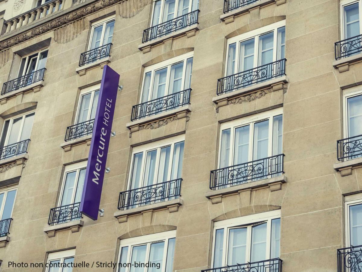 un bâtiment avec une enseigne violette sur le côté dans l'établissement Mercure Paris Opera Garnier Hôtel & Spa, à Paris