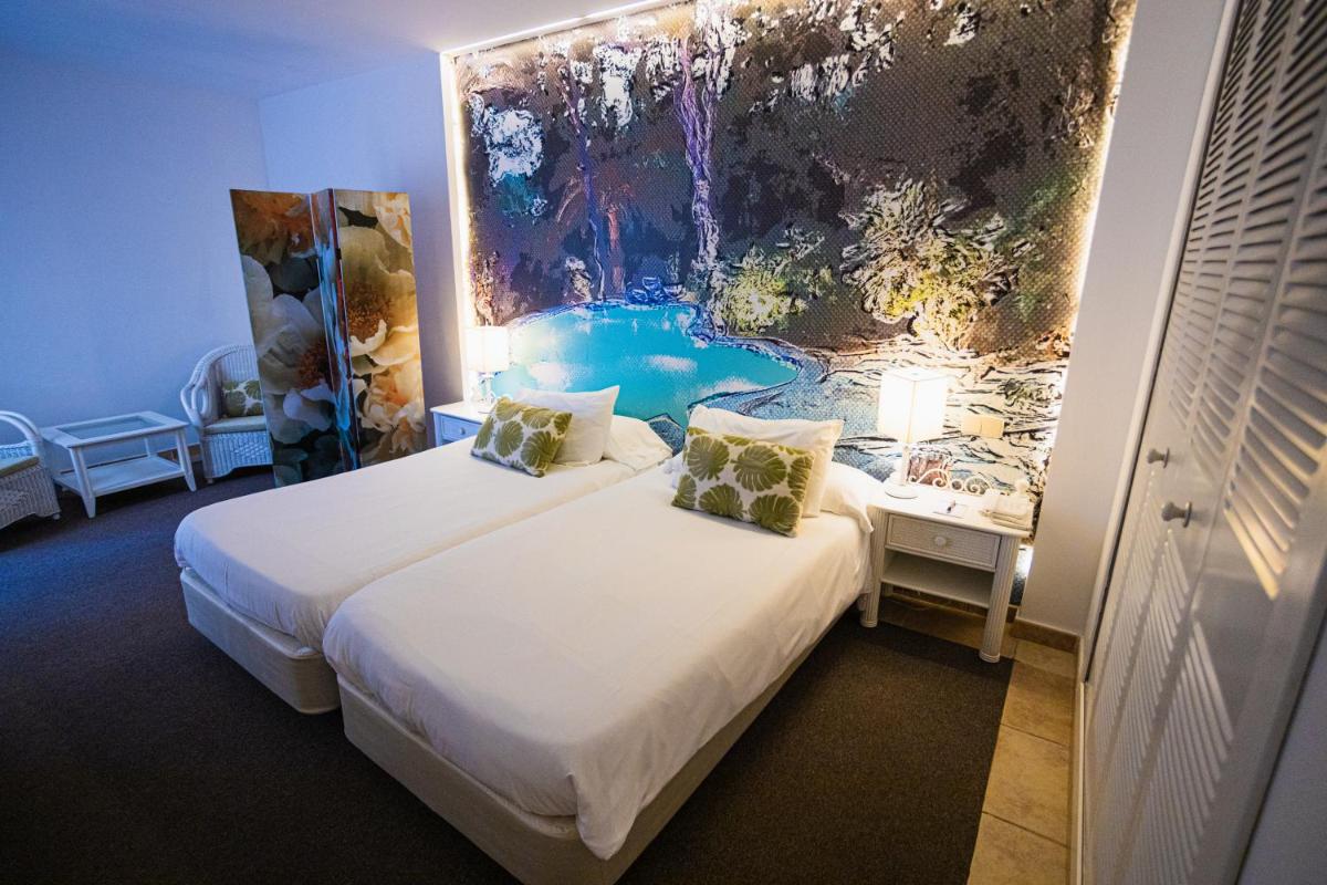 Una habitación con dos camas y un cuadro en la pared. en Lago Garden Apart-Suites & Spa Hotel, en Cala Ratjada 130 fotos más