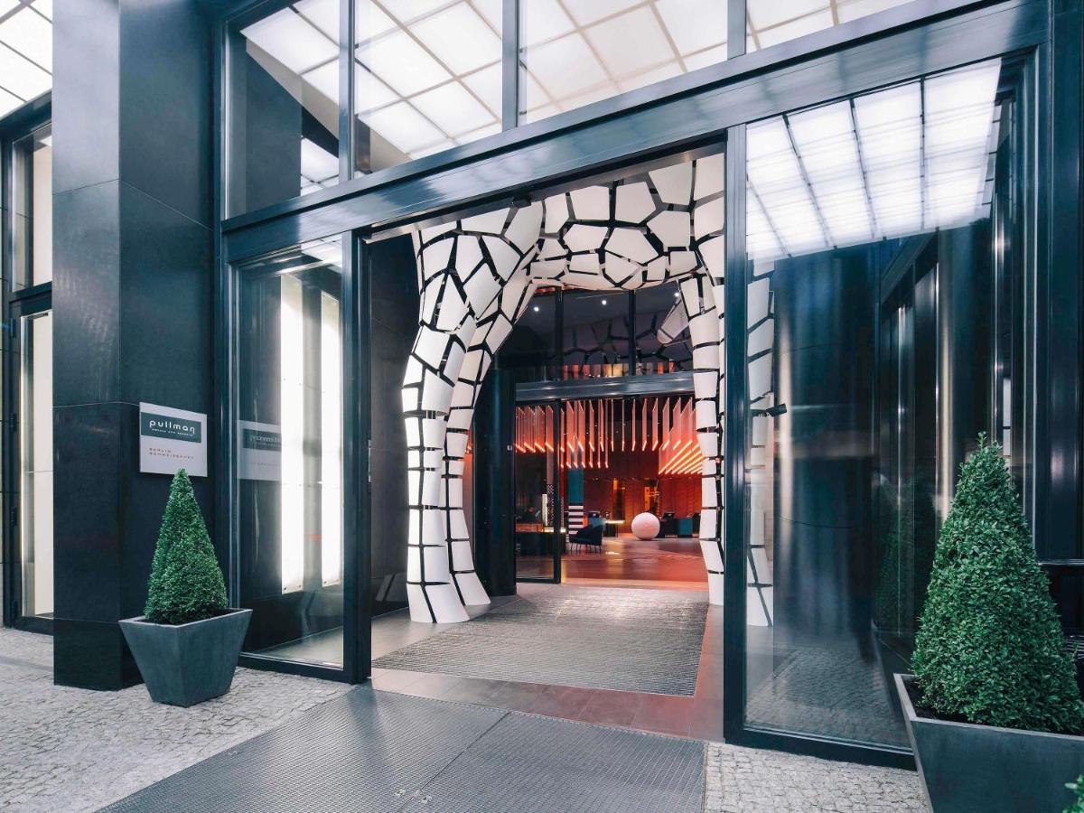 ein Eingang zu einem Gebäude mit Bäumen in einem Flur in der Unterkunft Pullman Berlin Schweizerhof in Berlin