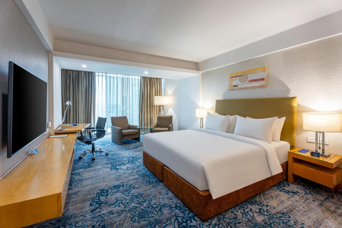 a hotel room with a bed and a flat screen tv at Radisson Blu Hotel Pune Kharadi in Pune