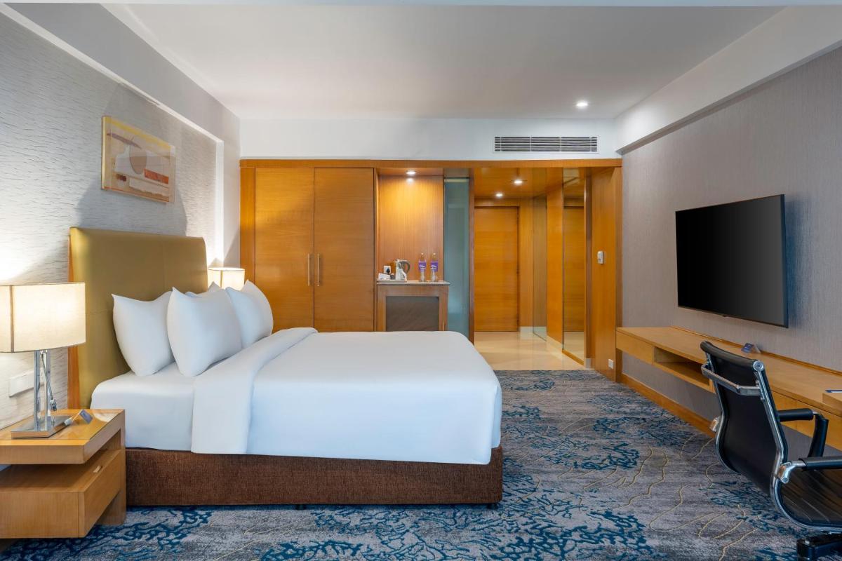 a hotel room with a bed and a television at Radisson Blu Hotel Pune Kharadi in Pune
