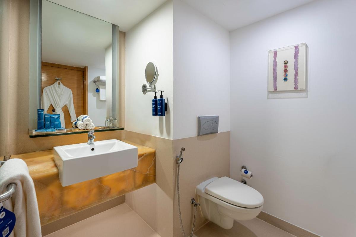 a bathroom with a sink and a toilet at Radisson Blu Hotel Pune Kharadi in Pune