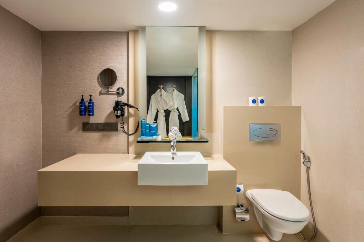 a bathroom with a sink and a toilet at Radisson Blu Hotel Pune Kharadi in Pune
